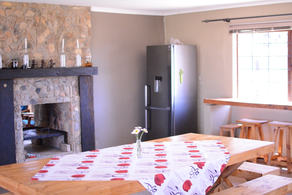 Dining area with stone fireplace and kitchen
